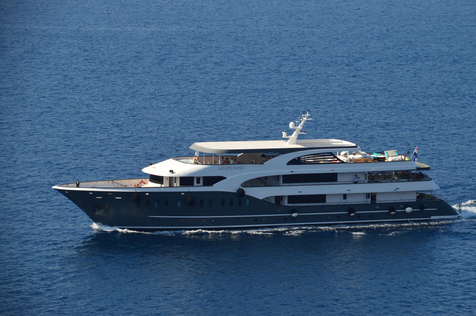 Luxury yacht cruising across calm blue water for private group charter planning
