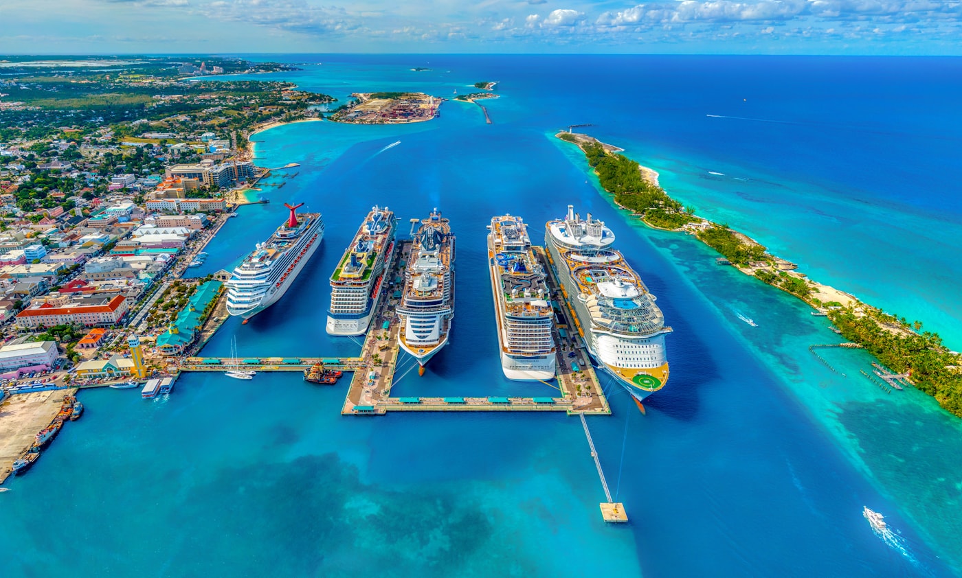 Cruise ships beside a turquoise coastline
